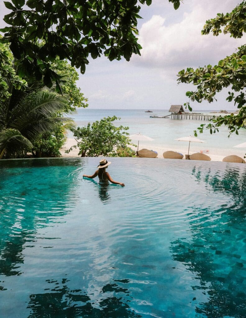 photo of woman swimming in pool in tropical region