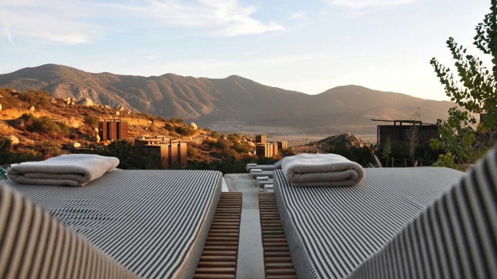 photo of lounge chairs looking out at the beach and hillside