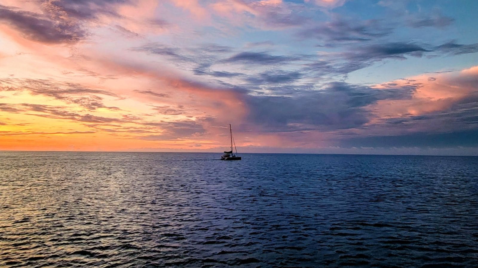 photo of sun setting in St Lucia with boat in the background