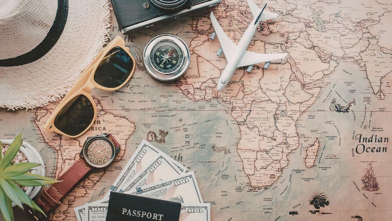 photo of map, compass, money, passport, sunglasses, and camera