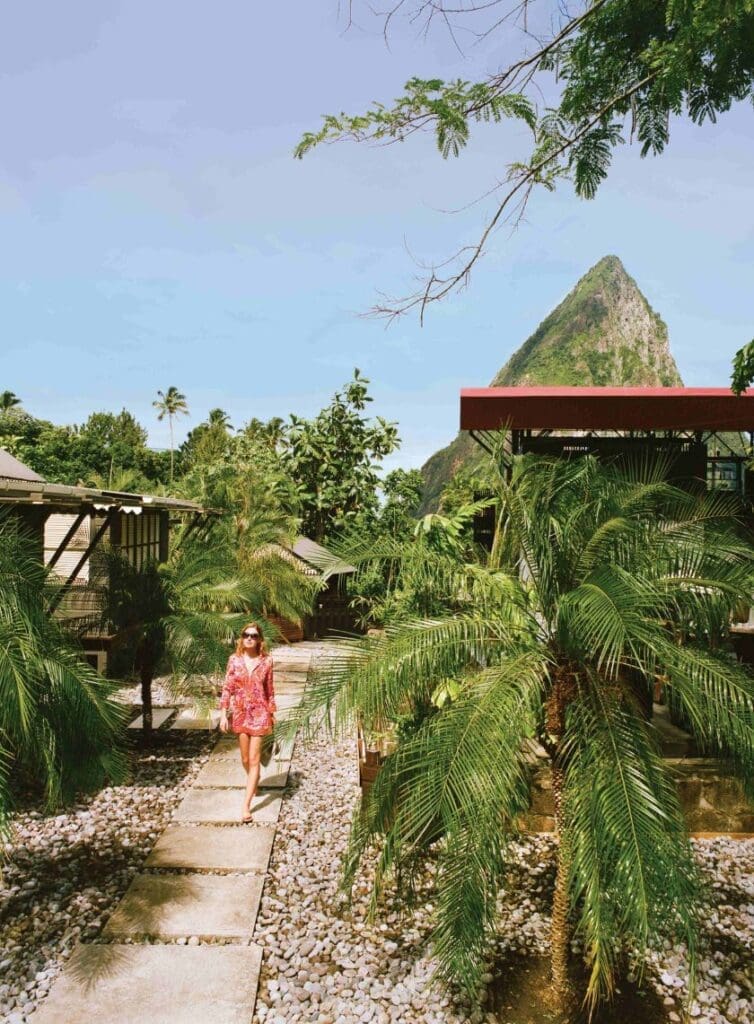 photo of woman walking through the Rabot Estate in St. Lucia with the Pitons behind her