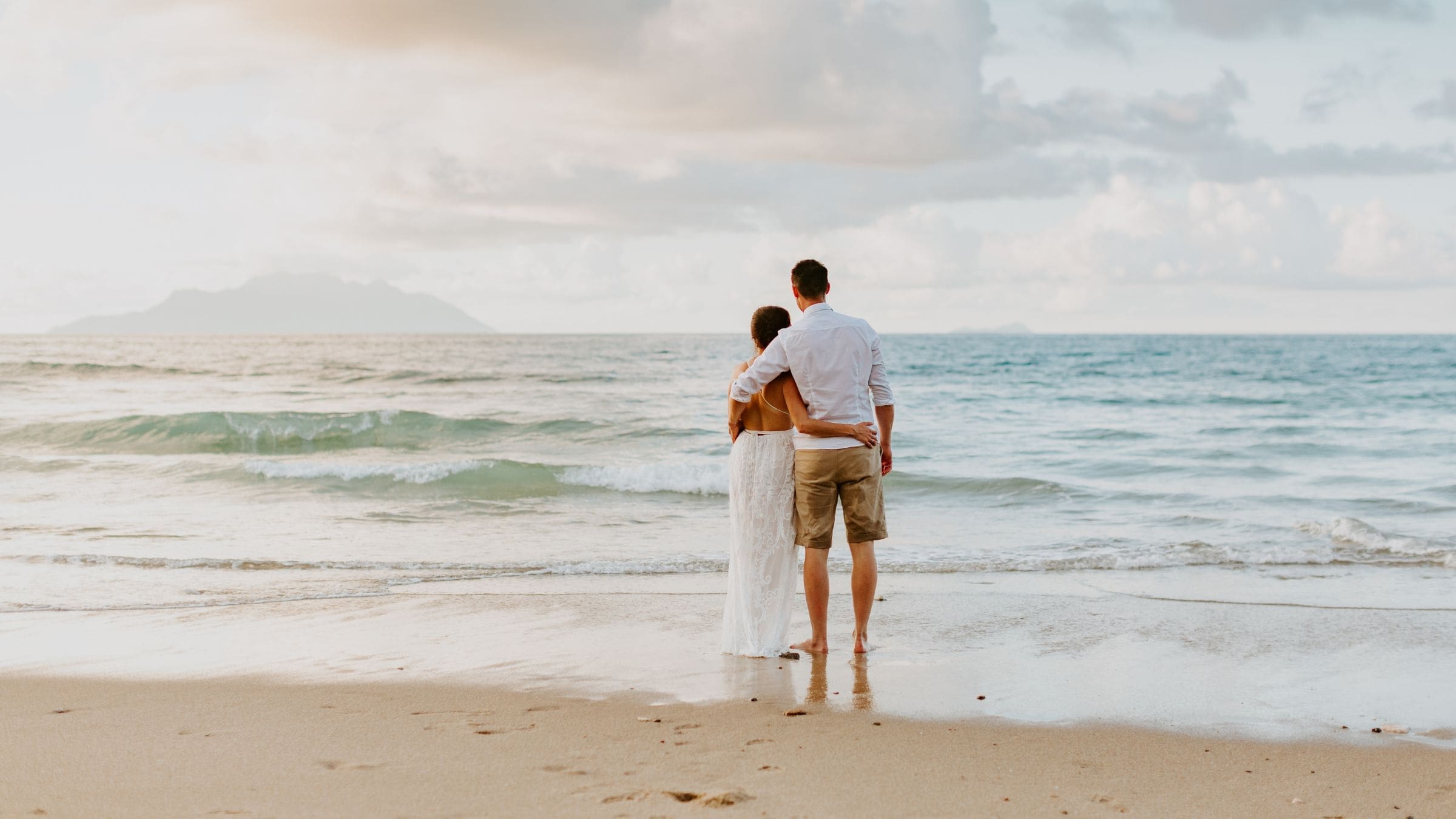 photo of couple embracing on the beach