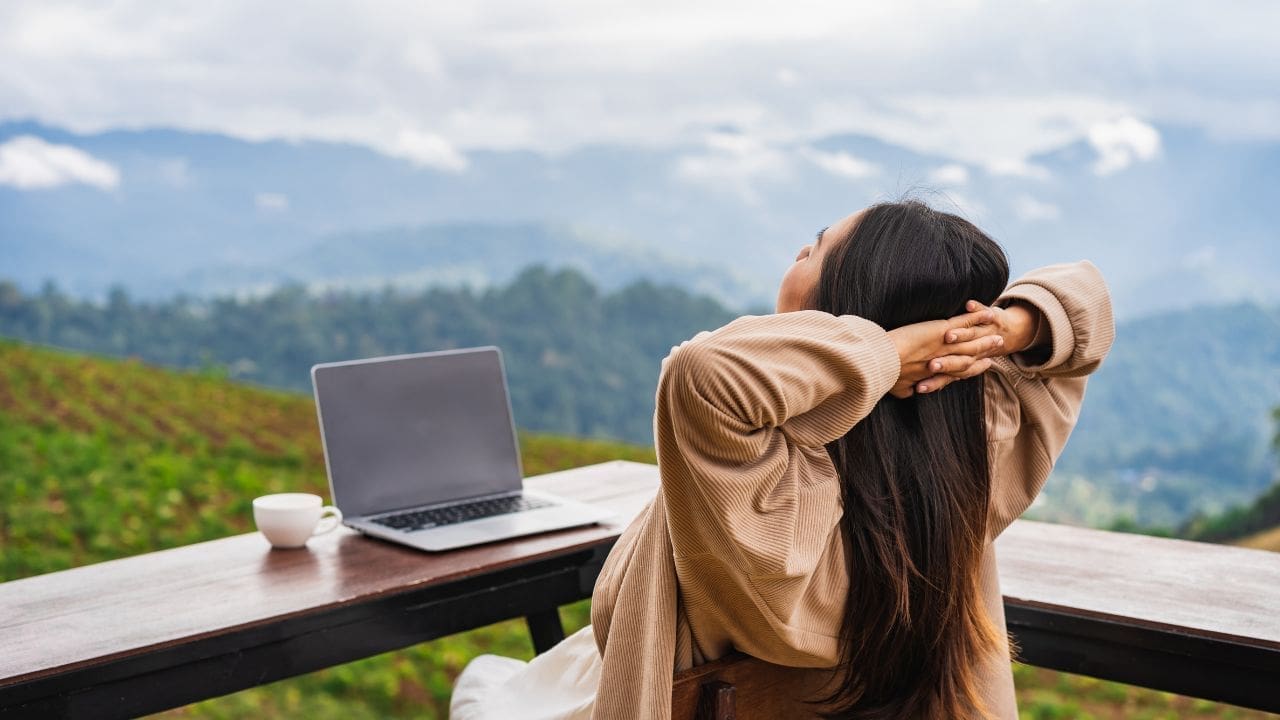 photo of woman relaxing with laptop and views in the distance