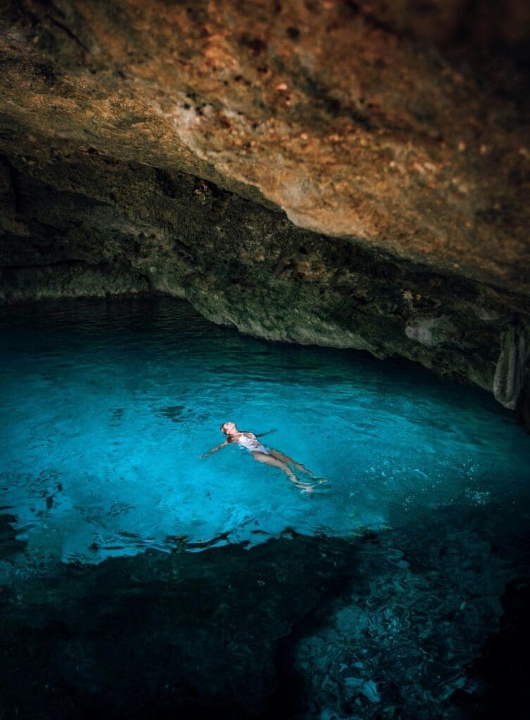 photo of woman floating in cenote in Mexico