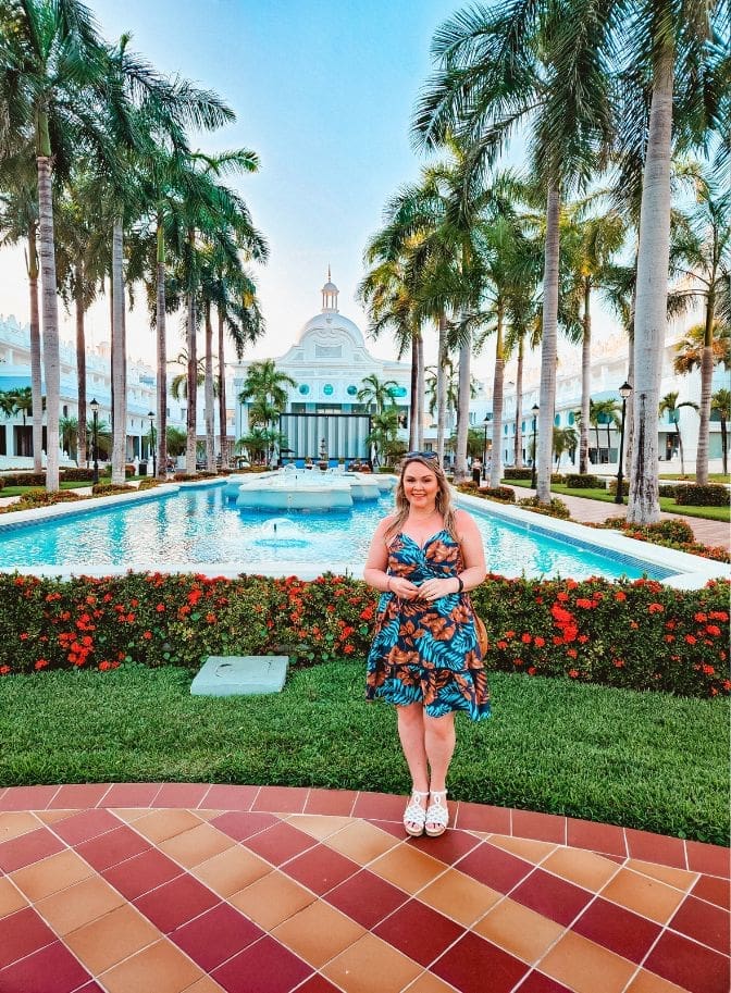 photo of woman standing in front of fountain at resort