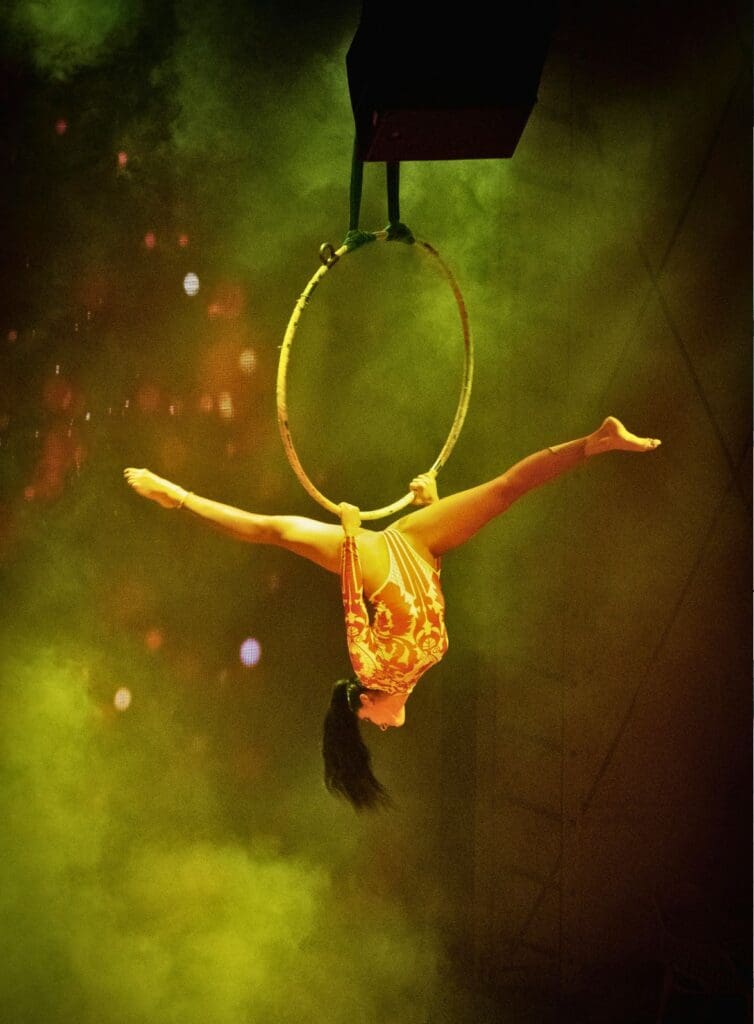 photo of woman upside down on an aerial hoop