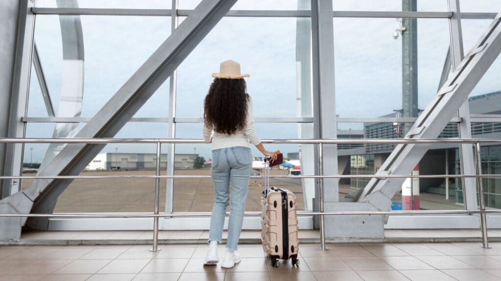 photo of woman at airport looking out windows