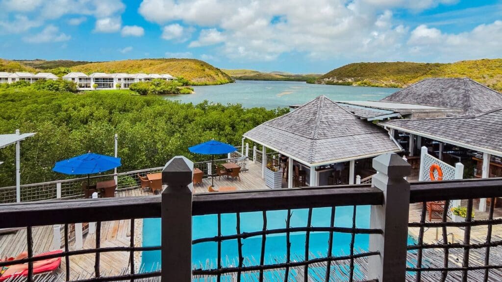 view of pool, bar, restaurant, and bay from the lobby of The Escape at Nonsuch Bay
